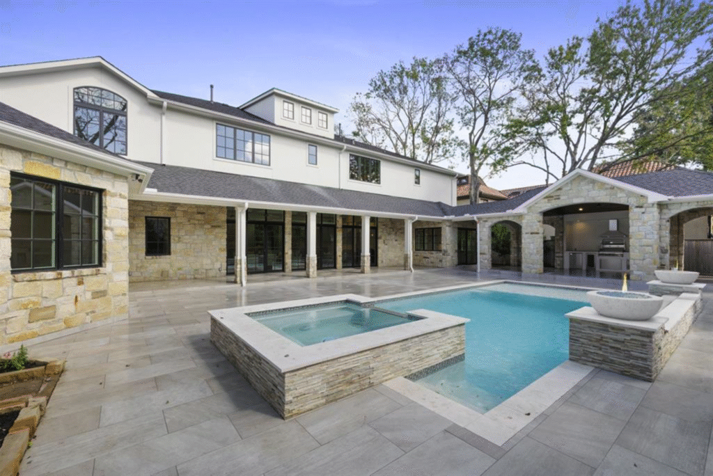 luxury-integrated-raised-spa-splitface-tile-tanglewood-houston An integrated raised pool spa featuring textured splitface tile masonry and custom stone coping in Tanglewood, Houston.