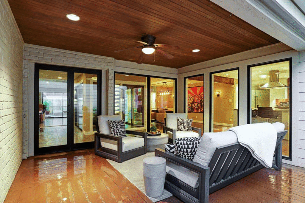 A custom stained wood deck with a matching patio cover and luxury outdoor furniture, illustrating high-end backyard deck and landscaping designs.