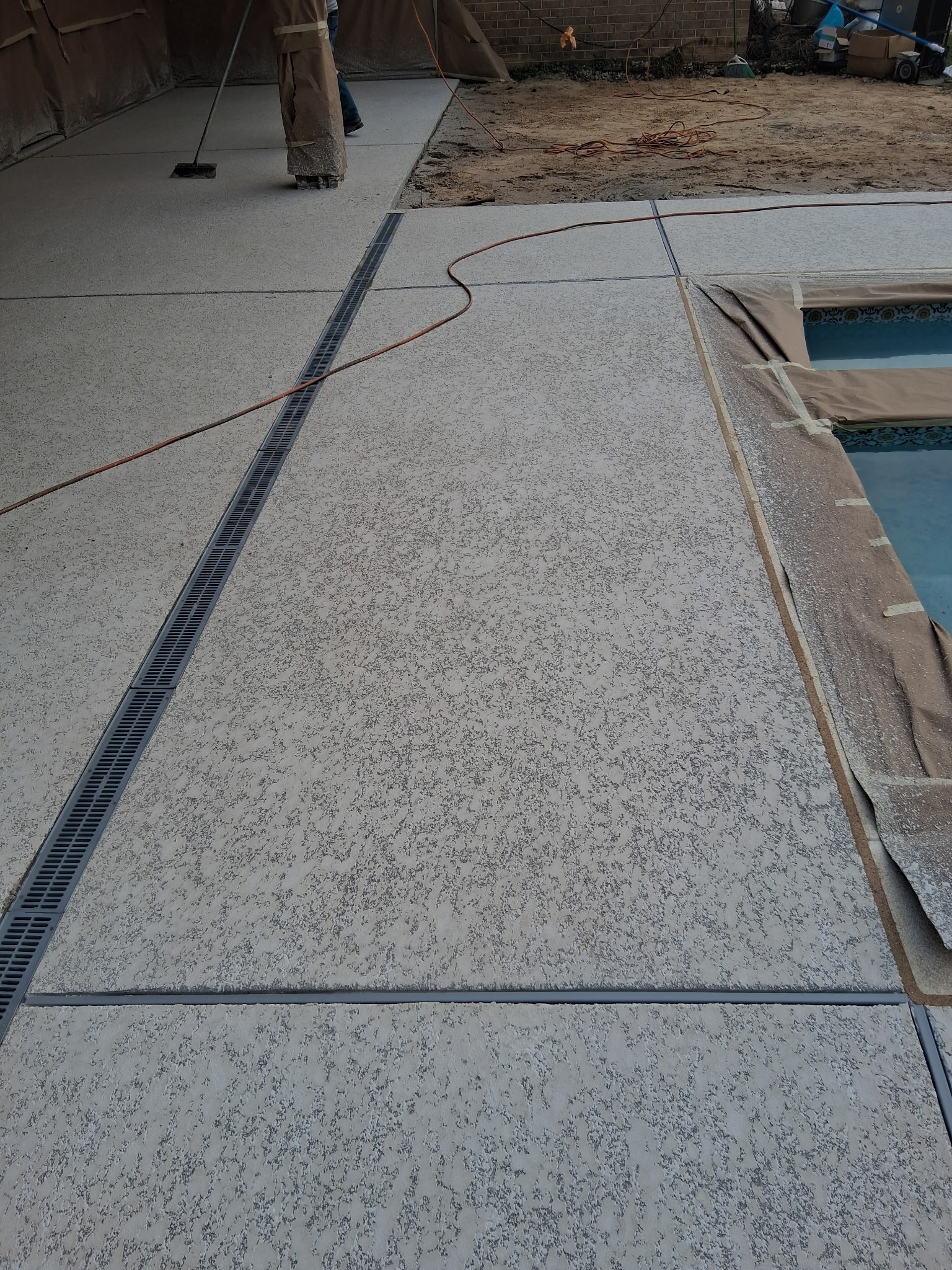 Knockdown spray deck on a luxury pool surround for a slip-resistant surface in Franciscan Tan color.