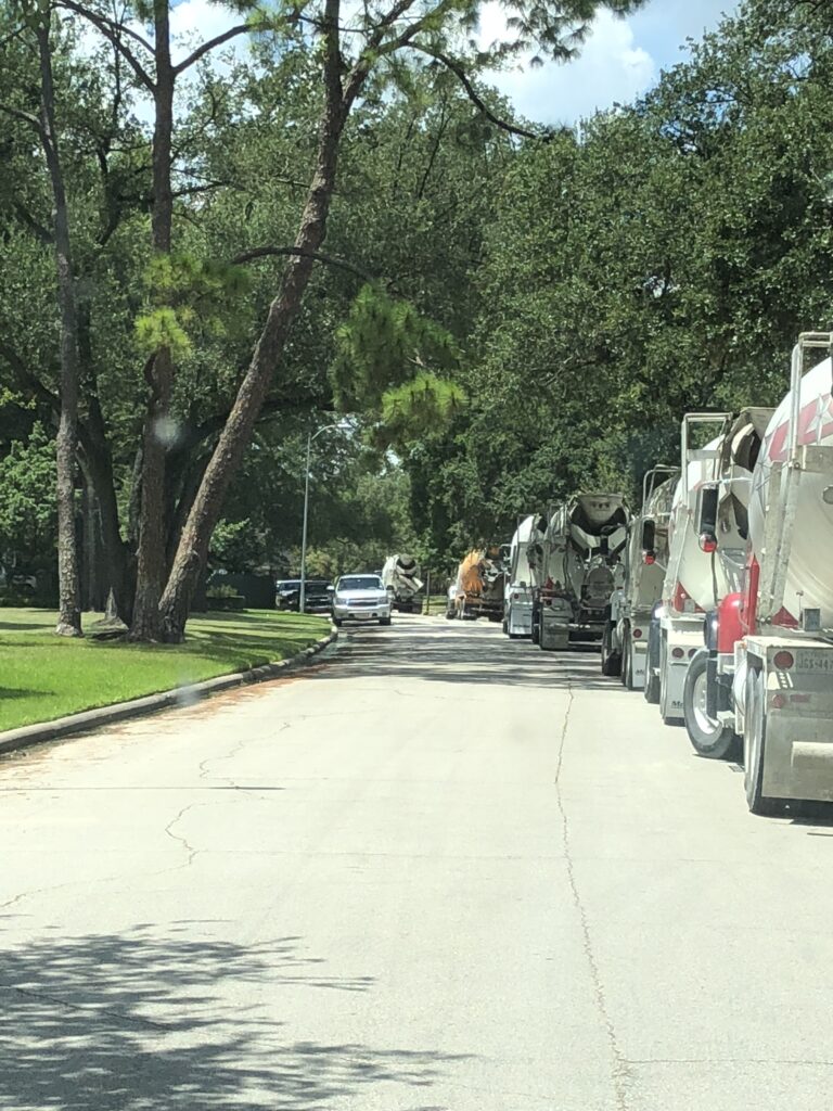 luxscape-custom-concrete-construction-houston-tanglewood-trucks Custom concrete construction in Houston showing seven concrete trucks delivering a massive pour to a Tanglewood job site.
