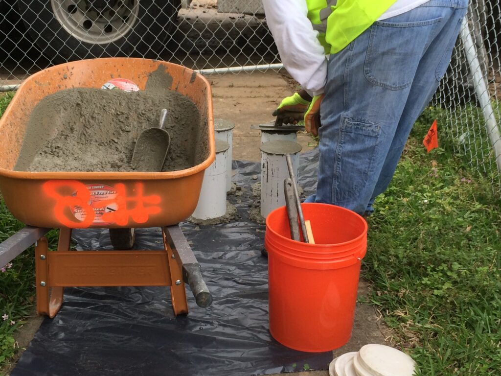 Concrete-Construction-Houston-Quality-Testing Concrete Construction in Houston quality control testing with engineers sampling fresh concrete from a truck.