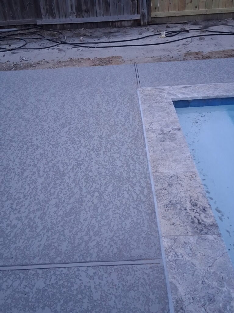 A texture-rich Spray Deck concrete overlay applied to a luxury pool deck, showcasing the slip-resistant finish from specialized Houston concrete resurfacing experts.