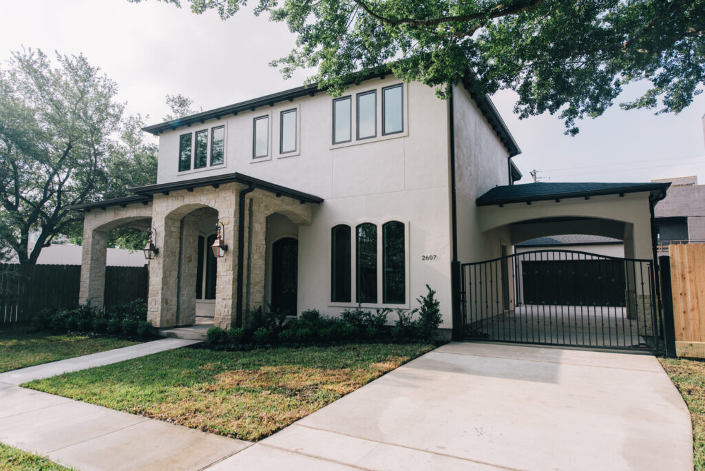 Professional pavers and concrete construction in Houston by Luxscape, featuring a custom concrete driveway, access gate, and porte cochere in West University Place.