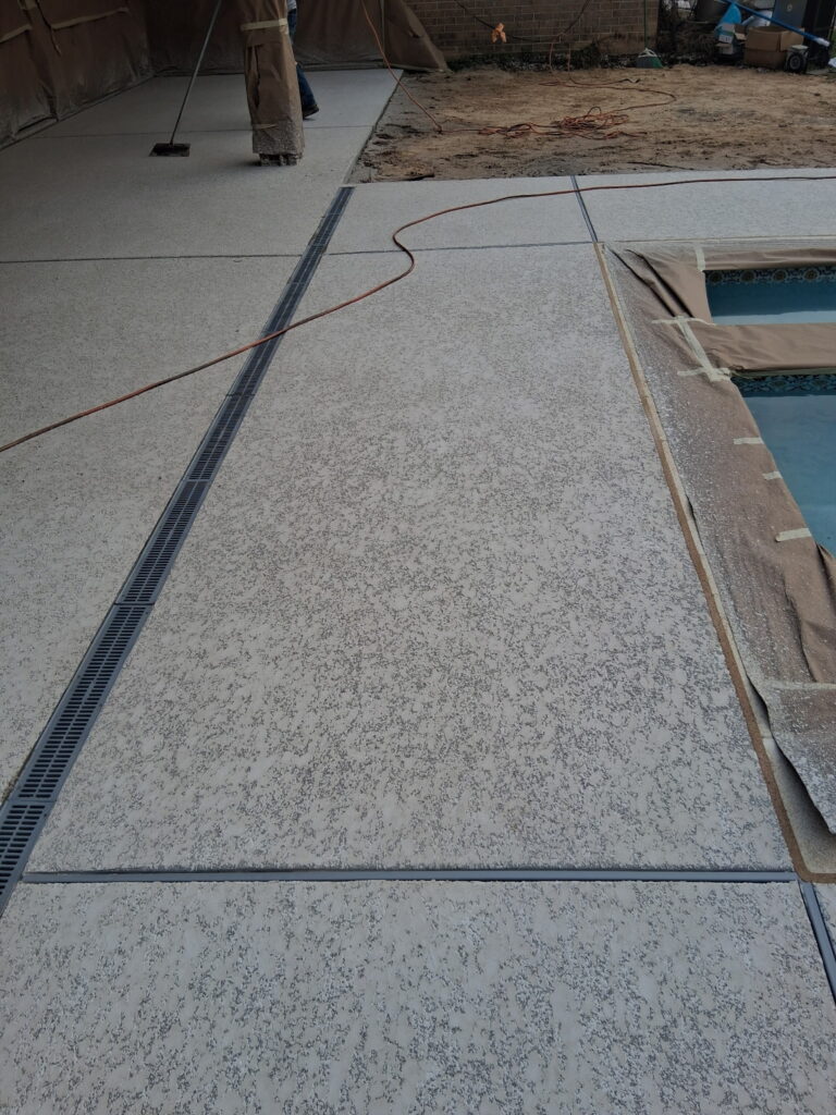 A Franciscan tan pool deck concrete overlay installed for a backyard by Luxscape, designed for Cypress homeowners by Luxscape Outdoor Builders serving Houston, TX.